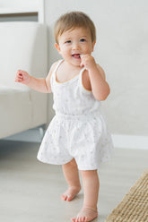 Baby walking indoors in Avauma Butter Daisy picnic tank top set